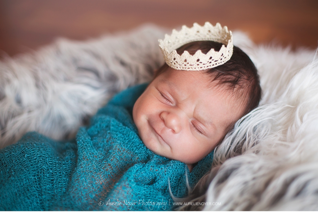photography of newborn with crown in blue